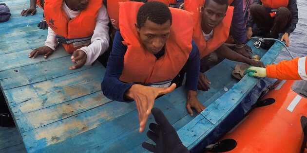 Migrants on wooden boat being rescued by "Save the Children" NGO crew from the ship Vos Hestia in the Mediterranean sea off Libya coast