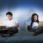 Couple au lit / Portra Images/ Getty