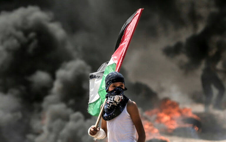 Un jeune garçon palestinien tient un drapeau palestinien lors de heurts avec les forces israéliennes