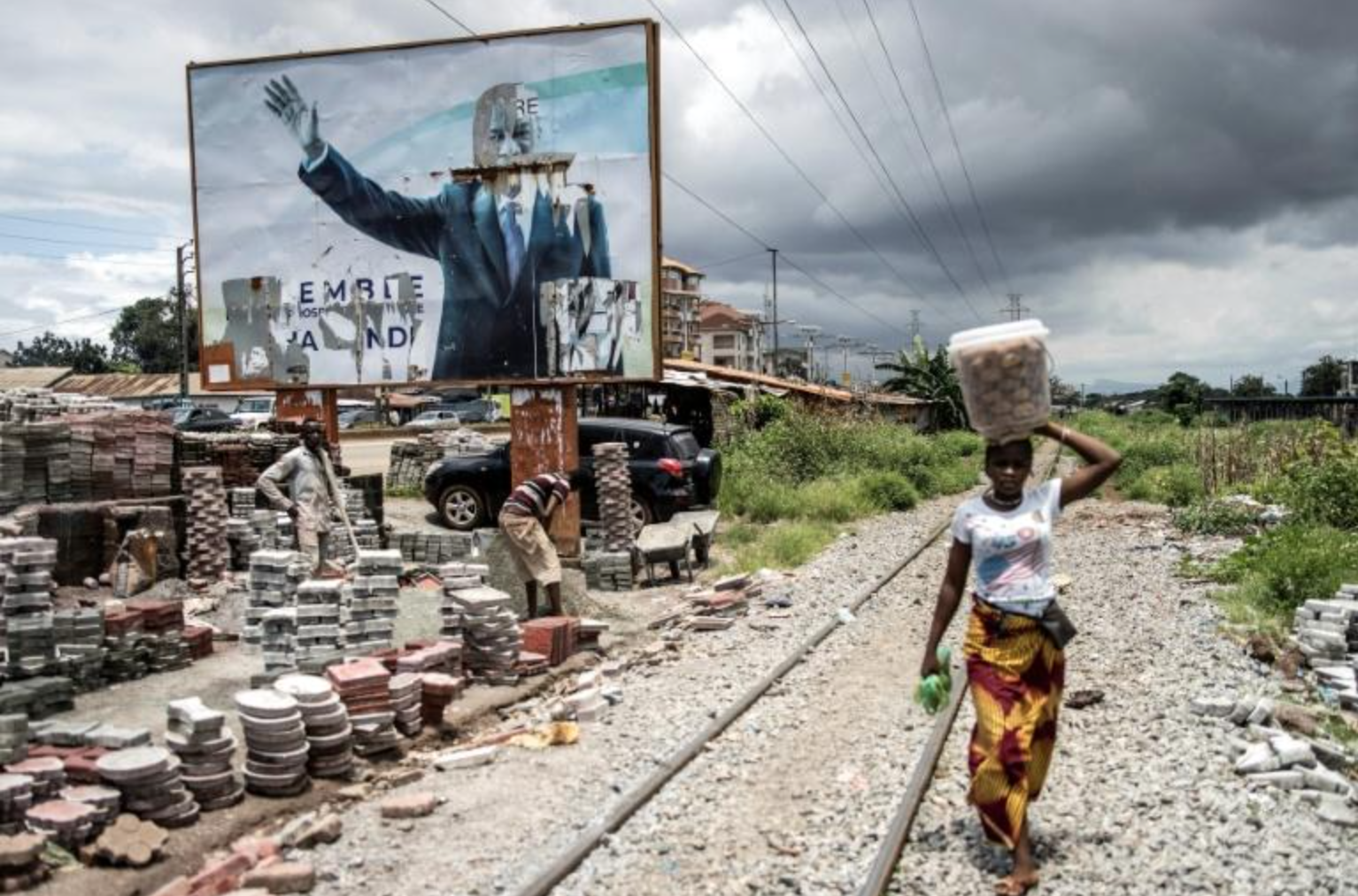 Une femme passe devant une affiche déchirée du président déchu de Guinée, Alpha Condé
