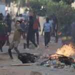 Un manifestant lance une pierre sur la police lors d'une manifestation dans un quartier de Dakar, au Sénégal, le samedi 3 juin 2023. (AP Photo/Leo Correa)