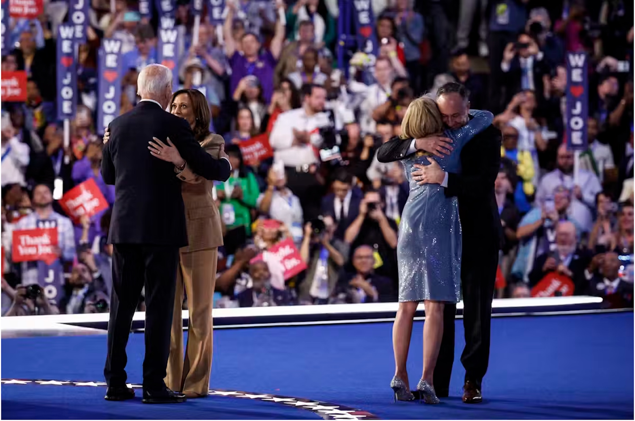 Kamala Harris et Tim Walz (de face) étreignent Joe et Jill Biden sur l’estrade du United Center, à Chicago, le 19 août 2024. Robyn Beck/AFP