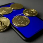 Prise de vue en studio de pièces d'or posées sur un smartphone affichant l'application Coinbase.