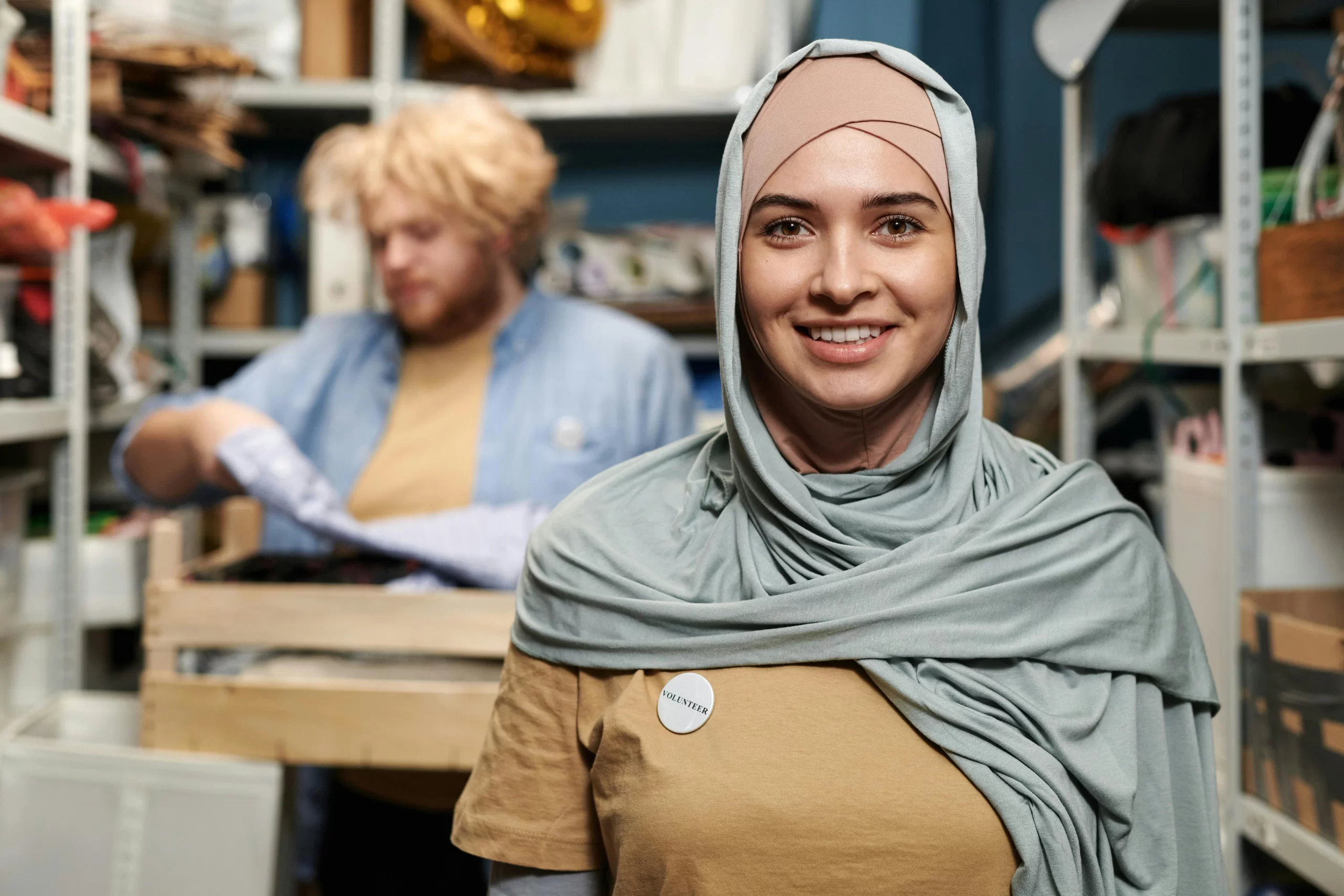 Femme en hijab gris souriant.